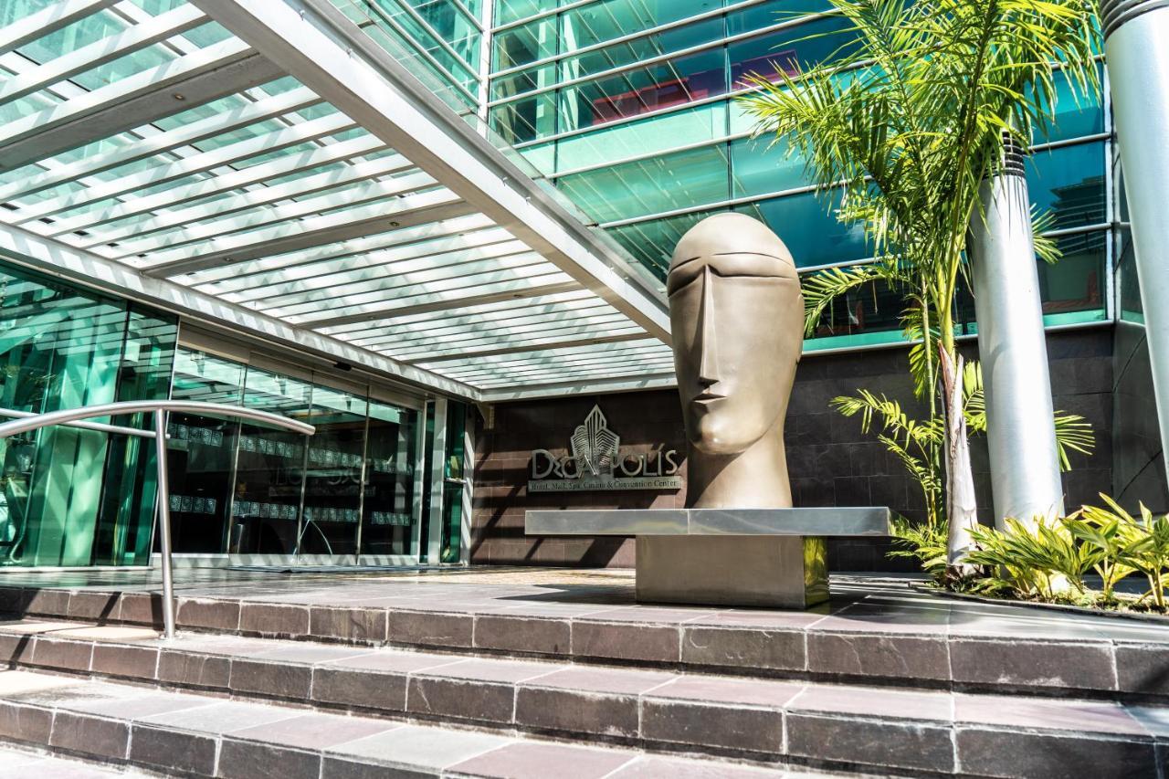 Decapolis Hotel Panama City Exterior photo The photo shows a modern architectural setting featuring a large, abstract sculpture of a head positioned on a stone step. The sculpture has a smooth, minimalist design, emphasizing a stylized face. Surrounding the sculpture are glass walls and an ov