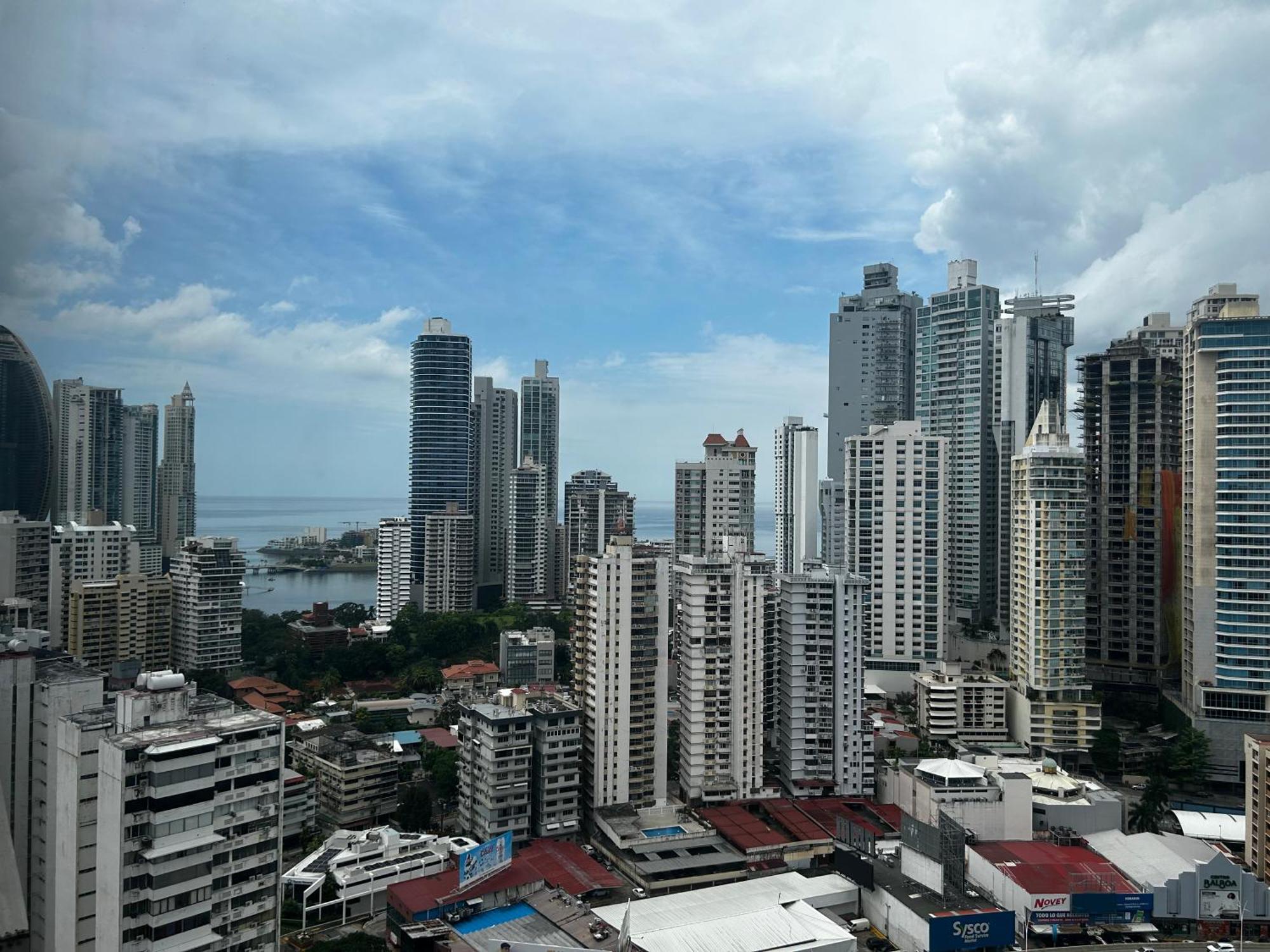 Decapolis Hotel Panama City Exterior photo The photo shows a city skyline with a mix of high-rise buildings and skyscrapers. In the foreground, there are several low-rise structures, and the buildings vary in design and height. The background features taller skyscrapers reaching into the sky,